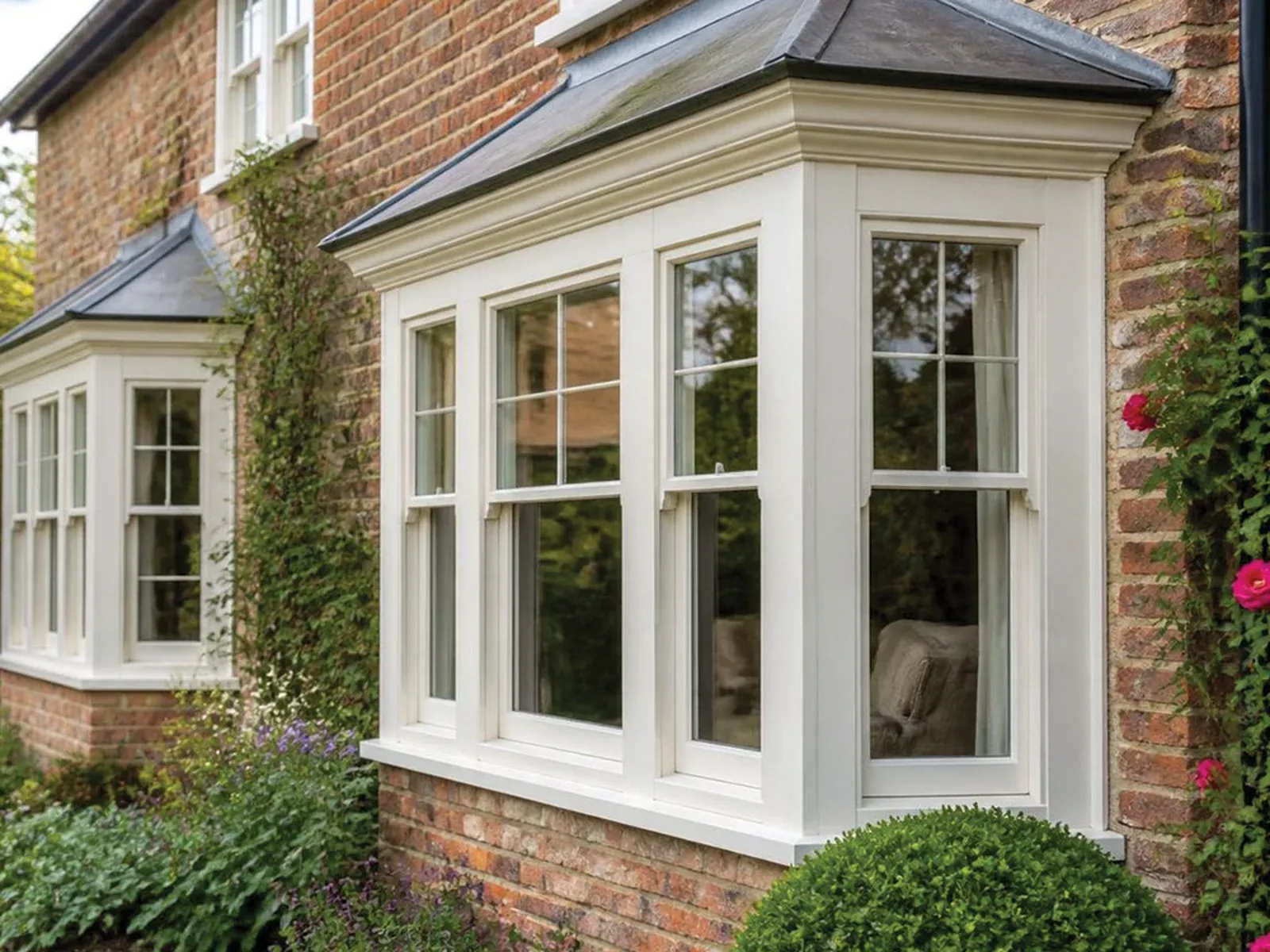 Traditional wooden sash bay windows on a red-brick home in Bromley, South East London